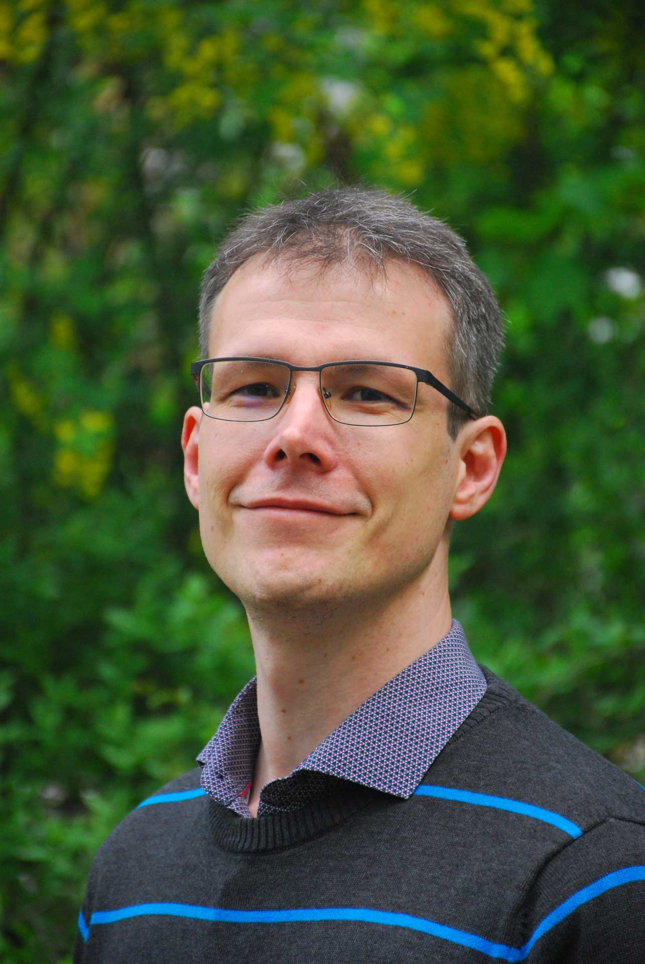 Ein mann mit Brille und einem gestreiften Pullover