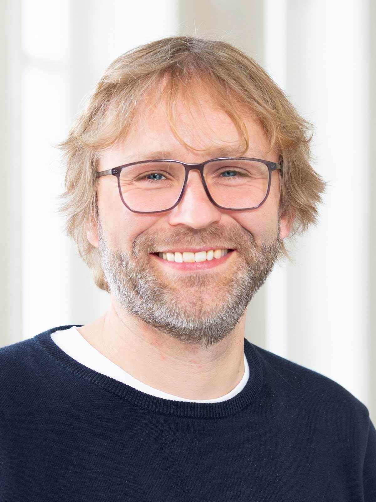 Portrait eines Mannes mit Brille und blonden Haaren